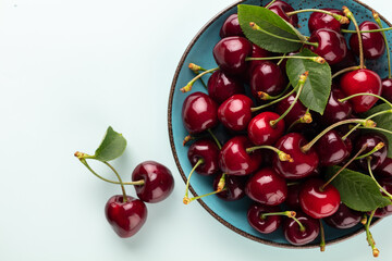 Cherry berries on a pastel background top view.  Background with a cherry on a sprig, flat lay