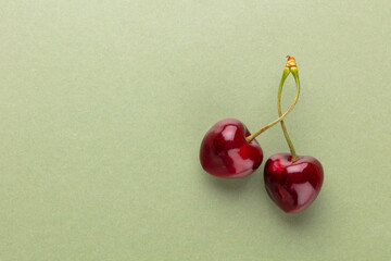 Cherry berries on a pastel background top view.  Background with a cherry on a sprig, flat lay