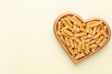 Pasta in a heart shaped wood bowl.