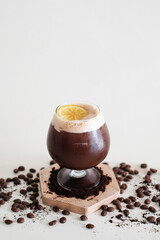 Short wine glass of Honey lemon americano shake top with yellow ,sour and sweet lemon slice. Decorated with midium rosted coffee beans and ground coffee on white background. Use for modern coffee shop
