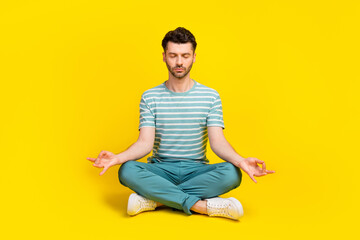 Full size photo of young man wear blue striped t-shirt pants meditation after work isolated on...
