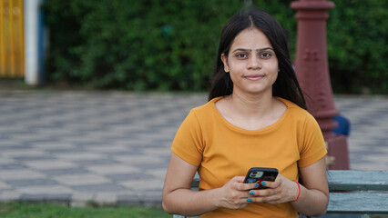 Young Indian girl using mobile phone in the outdoor