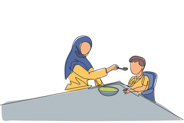 Single continuous line drawing of young Islamic mother feeding healthy food to son using spoon at home. Arabian muslim happy family motherhood concept. Trendy one line draw design vector illustration
