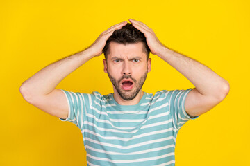 Closeup photo of young attractive funny guy reaction hands head shock how that happened isolated on yellow color background