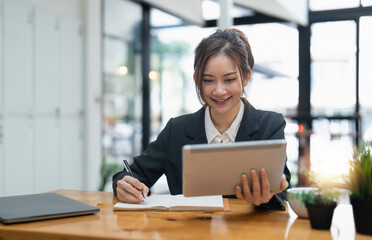 businesswoman using digital tablet and pen to take notes at office.