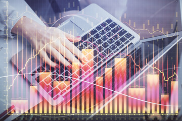Double exposure of businesswoman hands typing on computer and financial graph hologram drawing. Stock market analysis concept.