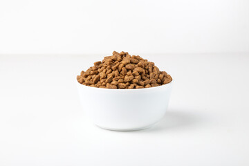 Food for cats and dogs in a white bowl on a white background.	