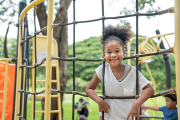 Obraz premium Portrait of happy African American girl smiling look at camera at playground in the park