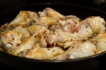 Chicken is fried in a frying pan close-up