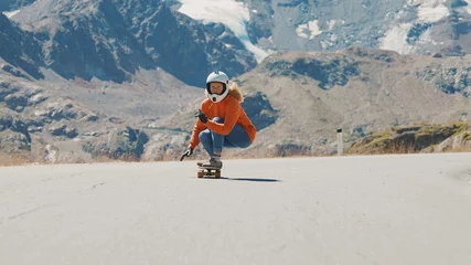 Küchenrückwand glas motiv Cinematic downhill longboard session. Young woman skateboarding and making tricks between the curves on a mountain pass. Concept about extreme sports and people © oneinchpunch