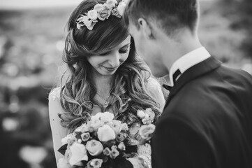 The happy face bride and groom stand after wedding ceremony. A newlywed couple hugging in a country...