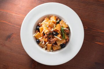 Piatto di maccheroni con ragu di salsiccia di maiale e olive nere, cibo italiano 