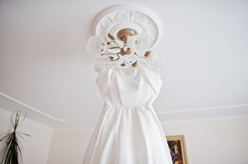 Wedding dress hanging ceiling. Bride day.