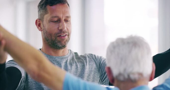 Male physical therapist helping old patient to stretch at the hospital. A happy physiotherapist in elderly care doing stretching exercises for a healthy body lifestyle, over copy space.