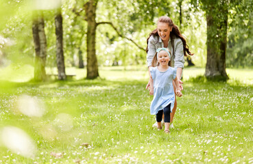 family, motherhood and people concept - happy mother with little daughter playing at summer park