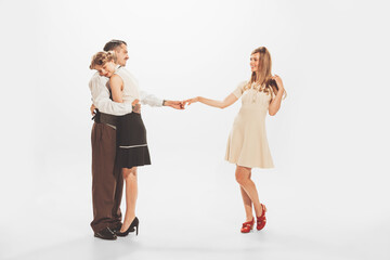 Obraz premium Portrait of young man hugging woman and giving hand to another girl. Flirty relationship