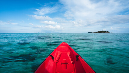 First person view of adventure sea kayak heading to Koh Kra small island. Floating on crystal clear turquoise water and coral reef against summer blue sky. Koh Lipe Island, Satun, Thailand. - obrazy, fototapety, plakaty
