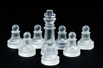 transparent glass chess on black background, selective focus on king piece, close up