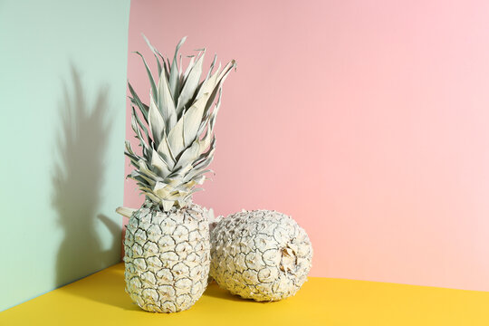 White pineapples on color background, space for text. Creative concept