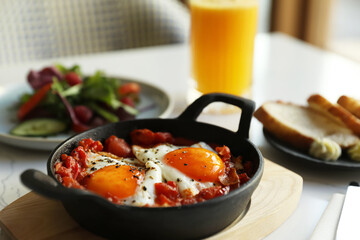Tasty Shakshouka served on white table. Traditional Arabic dish