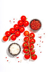 Cooking background with tomato cherry, sea salt, and rose peppercorn isolated on white background