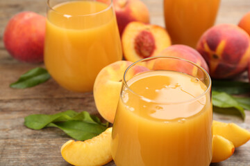 Natural peach juice and fresh fruits on wooden table, closeup