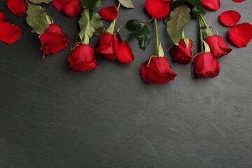 Beautiful red roses and space for text on black background, flat lay. Valentine's Day celebration