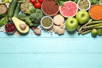 Fresh vegetables, fruits and seeds on light blue wooden table, flat lay. Space for text - obrazy, fototapety, plakaty