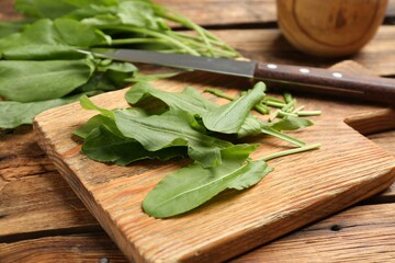 Fresh cut sorrel leaves on wooden table, closeup