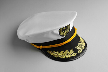 Peaked cap with accessories on light grey background
