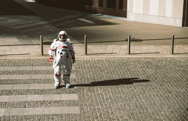 spaceman in a futuristic station. Man with space suit walking in an urban area