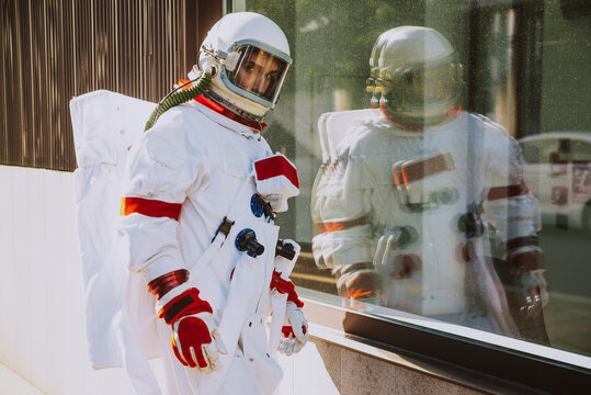 spaceman in a futuristic station. Man with space suit walking in an urban area