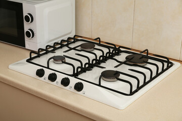 Modern gas cooktop and microwave oven in kitchen