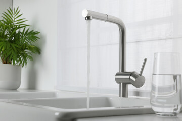 Stream of water flowing from tap in kitchen