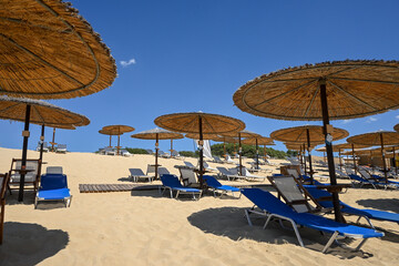 empty sunbeds and straw umbrellas