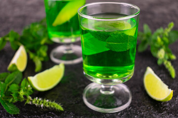 Alcoholic mint liqueur with lime on a black background.Close-up.
