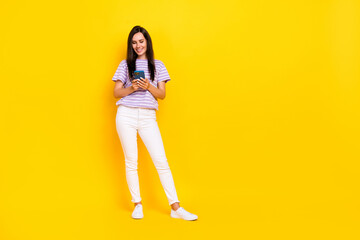 Fototapeta na wymiar Full size photo of pretty lady arm hold telephone device write post stand trendy outfit empty space isolated on yellow color background
