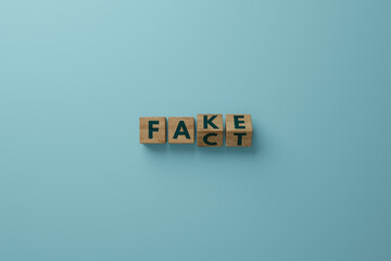 Wooden cubes with the word FACT and a change to FAKE. Concept of wrong information, false fakes. 3d...