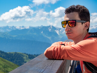 Portrait of young man wearing mirrored polarized sunglasses at mountains background