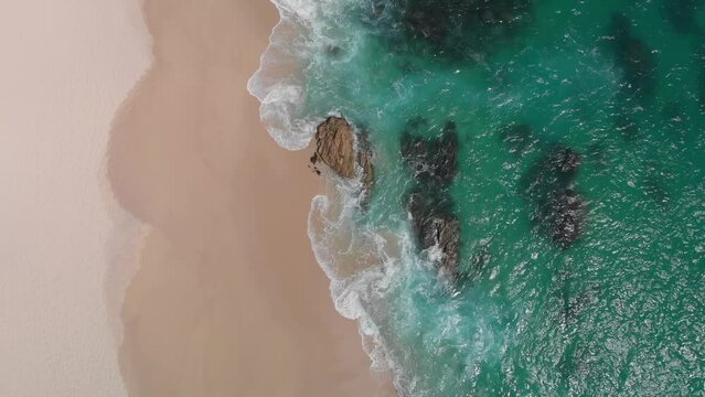 Rocks on the beach on Los Cabos, Baja California, Mexico. Side view from drone at beach and azure sea. Travel and vacation video
