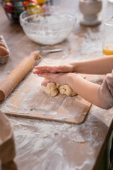 In front of the camera beautiful girl happy and smiling large shaking hands to the camera while preparing the delicious biscuits for all family