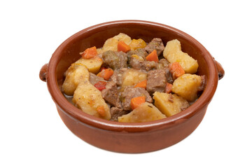 An earthenware bowl with hungarian goulash, beef, pork stew with potatoes, isolated on white background. It is a spicy dish, made mainly with meat, onions, peppers and paprika.