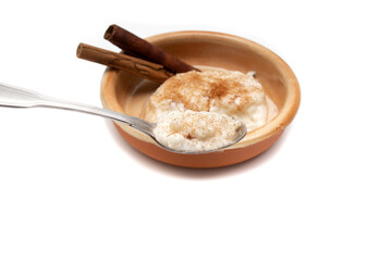 Delicious rice pudding with cinnamon isolated on white. Rice pudding is a typical dessert of the gastronomy of many countries made by slowly cooking rice with milk and sugar.