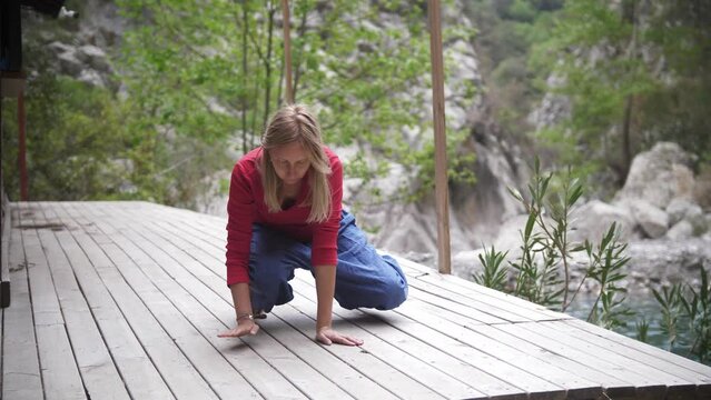 Yoga by the lake - blonde woman rises to her feet from