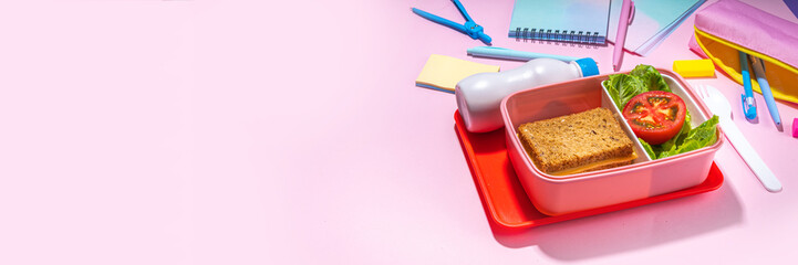 Healthy school meal, back to school concept. Children packed lunch box with balanced diet snack food - yogurt, cereal toast sandwich, apple, fresh vegetable salad, high-colored bright background