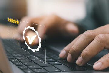 Businessman's hands typing on laptop keyboard showing quality assurance with icons, accreditation...