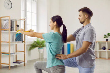 Physical recovery with rehabilitation specialist. Female patient with elastic band does stretching...