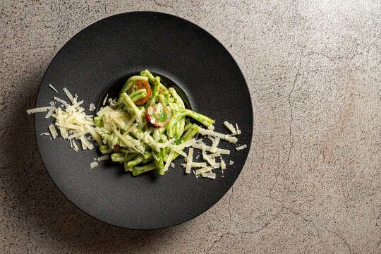 Top view of Troffi al pesto with parmessano a traditional Italian dish on a concrete background. High quality photo