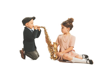 Cute happy kids playing with saxophone isolated on white studio background. Retro vintage style...