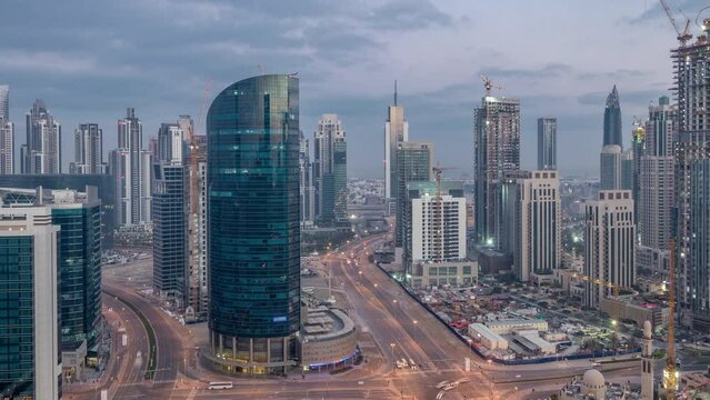 Dubai Downtown and Business bay night to day transition timelapse. Aerial panoramic view over big futuristic city. Skyscrapers of Dubai, United Arab Emirates. Morning skyline from rooftop